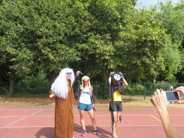 3 runners dressed in fancy dress standing on running track