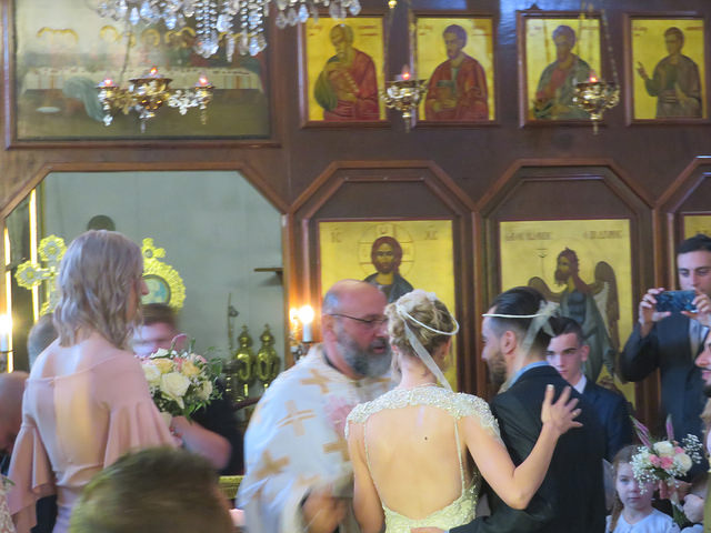 Bride and groom in front of priest. Behind alter are gold icons of saints