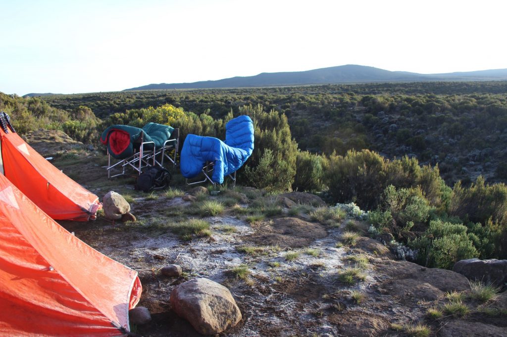 Tents and ground, covered in Frst. Sleeping bags over chairs drying in sun