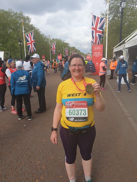 Holding up medal a tthe end of London Marathon