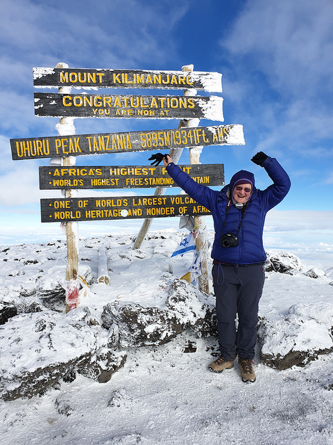 Me in front of the wooden sign on top of Kibo, the main summit of Kilimanjaro,, Snow on the ground