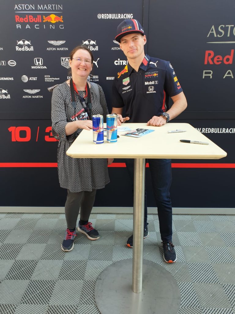 Me, next to Max Verstappen, standing in front of a Red Bull back drop