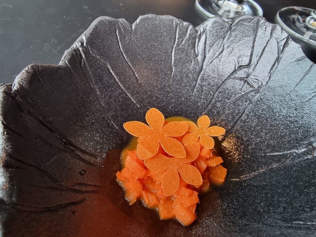 Carrots in various form on a black dish