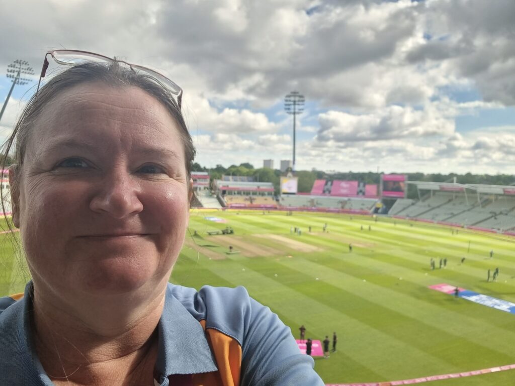 Selfie of me in volunteer uniform with Edgbaston Cricket pitch in background