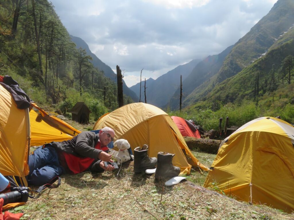 tents, with team member lying in son. Small green toilet tent in background