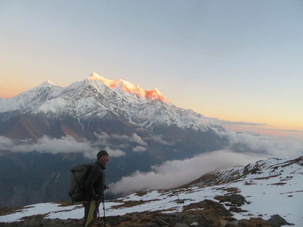 Dawa, head sherpa, standing, with sun glowed Annapurnas in the background