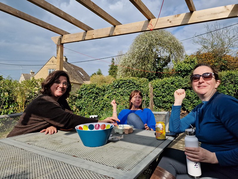 Picture of 3 members of Wine club at patio table with tea, water and crisps